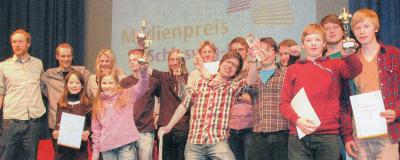 Mit den Trophäen in der Hand: Alle Gewinner des Medienpreises stellten sich auf der Bühne den Fotografen - vorne links Charlotte Kaiser und Sofia Brandt aus Bordesholm.